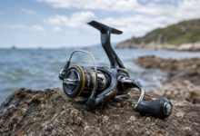 Shimano Nasci FC inceleme görseli. Kayalık kıyıda konumlandırılmış Shimano Nasci FC spin olta makinesi.